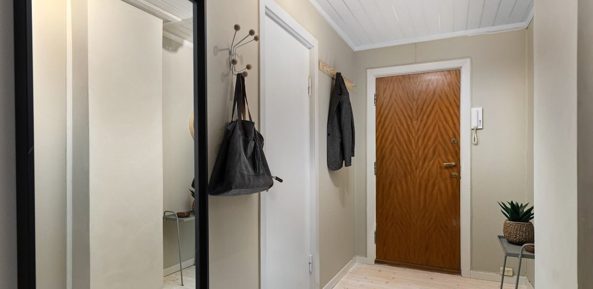 A hallway with a mirror and a coat rack