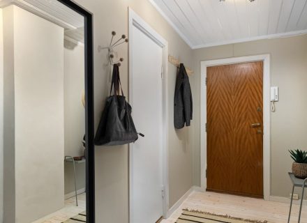 A hallway with a mirror and a coat rack