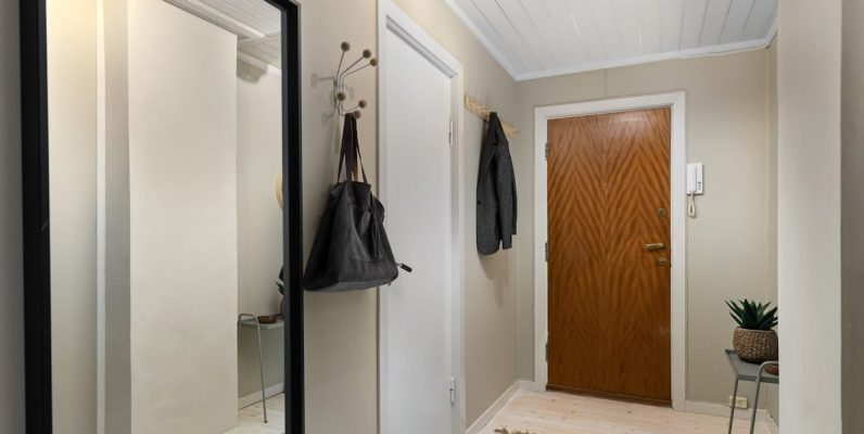 A hallway with a mirror and a coat rack