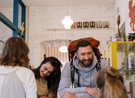 Backpackers cheerfully checking in at a vibrant hostel reception desk.
